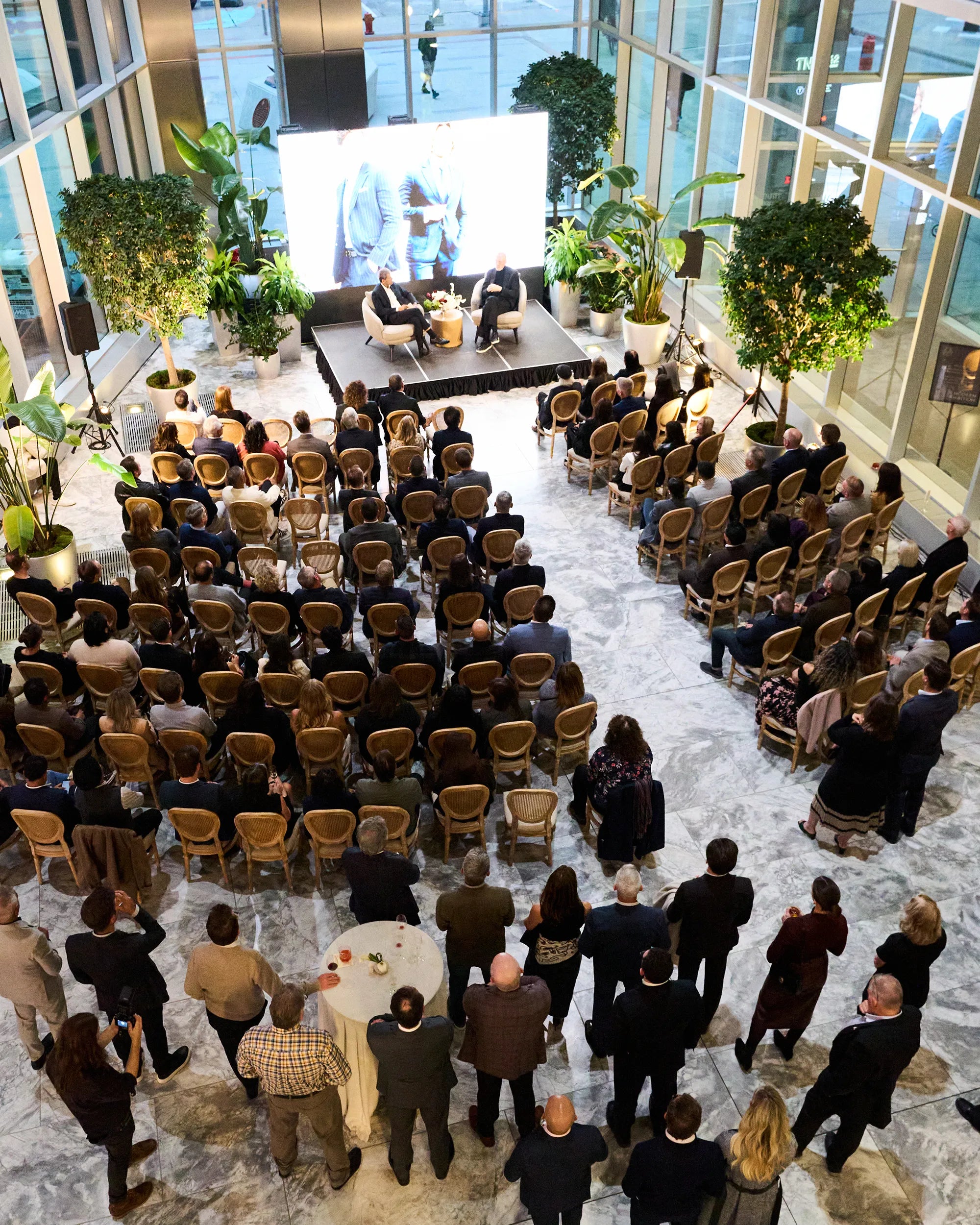 Large conference room with attendees facing a stage and screen.