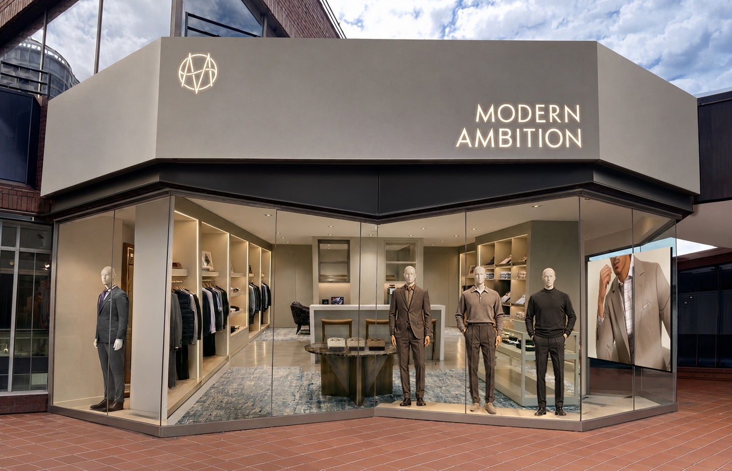Storefront showing a three-sided tall cement fascia displaying glowing 'Modern Ambition' signage, and v shaped display window with mannequins showing the store interior.
